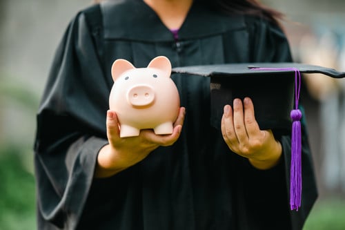 Graduate with piggy bank
